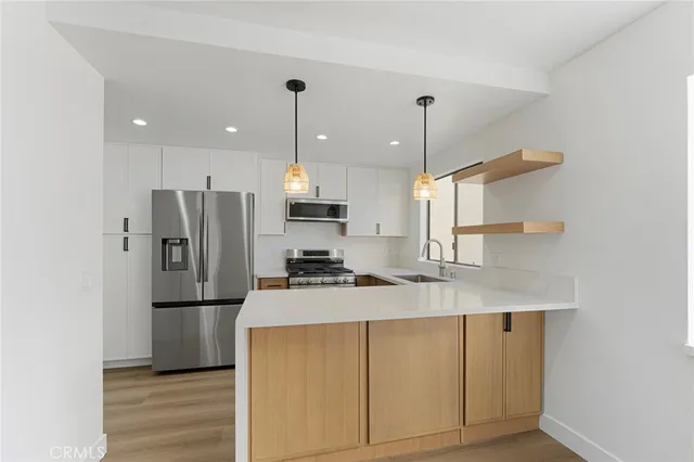 a kitchen with stainless steel appliances a refrigerator sink and microwave