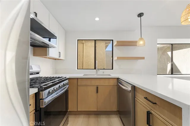 a kitchen with cabinets appliances and a window