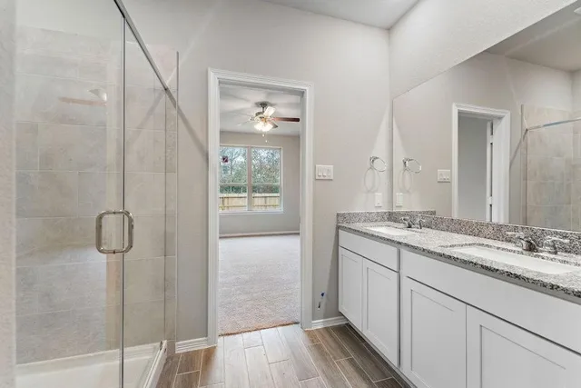 a bathroom with a granite countertop sink a mirror and a shower