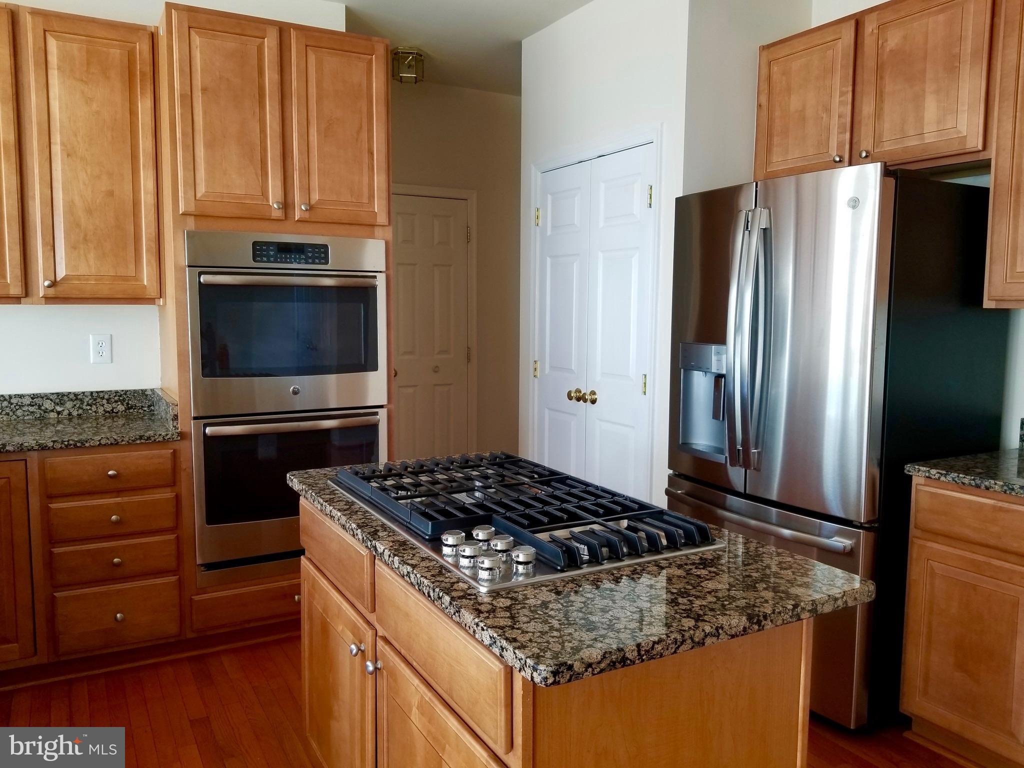 54 Watercourse Drive Ranson, WV 25438 - Photo 11 of 30 a kitchen with granite countertop a sink stove and refrigerator