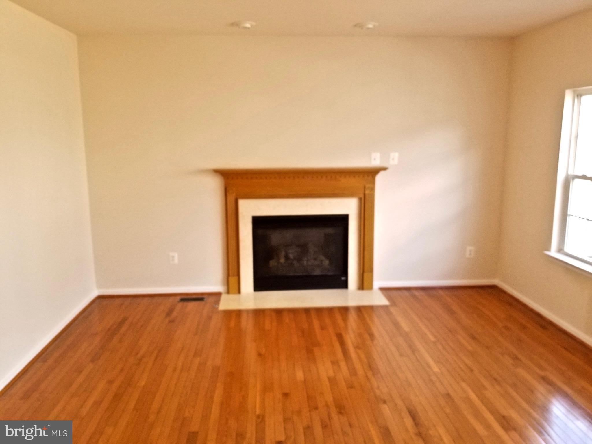 54 Watercourse Drive Ranson, WV 25438 - Photo 7 of 30 a view of an empty room with wooden floor and a fireplace