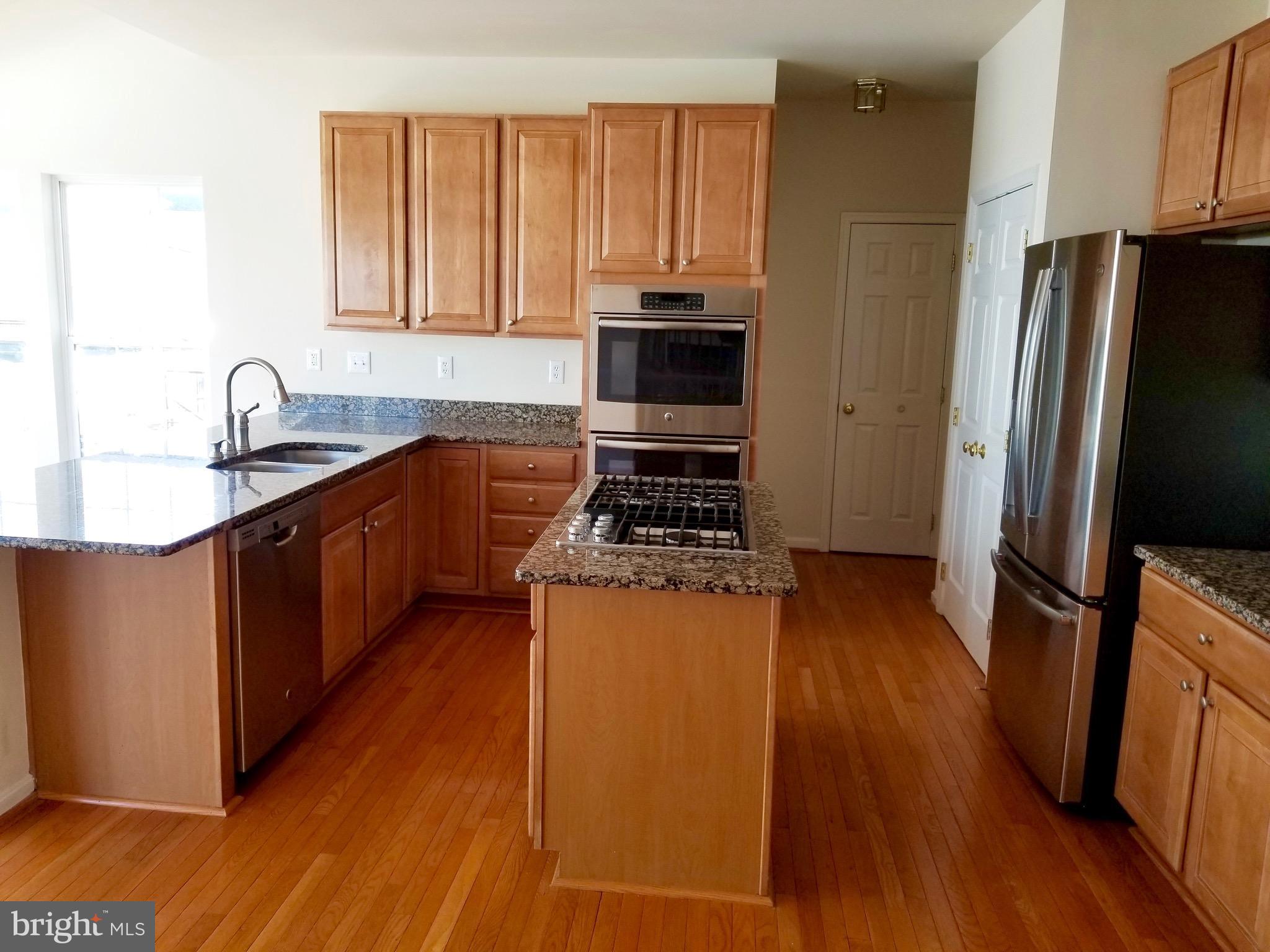 54 Watercourse Drive Ranson, WV 25438 - Photo 9 of 30 a kitchen with stainless steel appliances granite countertop a refrigerator a stove top oven a sink and dishwasher with wooden floor