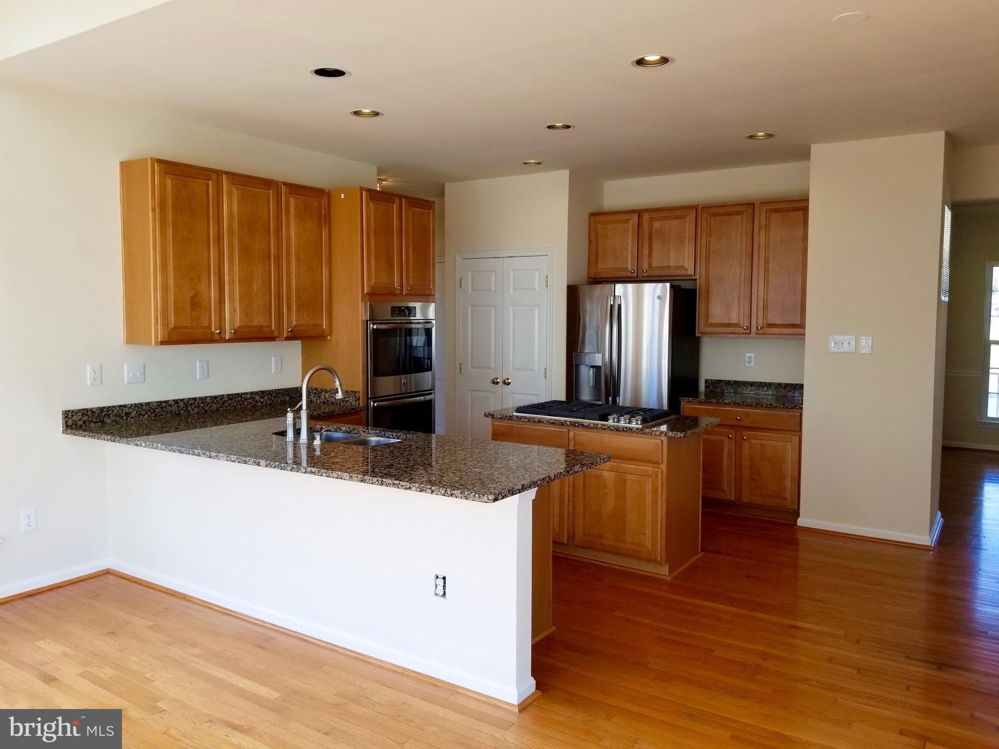54 Watercourse Drive Ranson, WV 25438 - Photo 10 of 30 a kitchen with stainless steel appliances granite countertop a refrigerator a sink dishwasher a stove with wooden floors