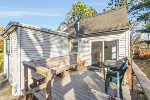 a view of a patio with table and chairs with wooden floor and fence