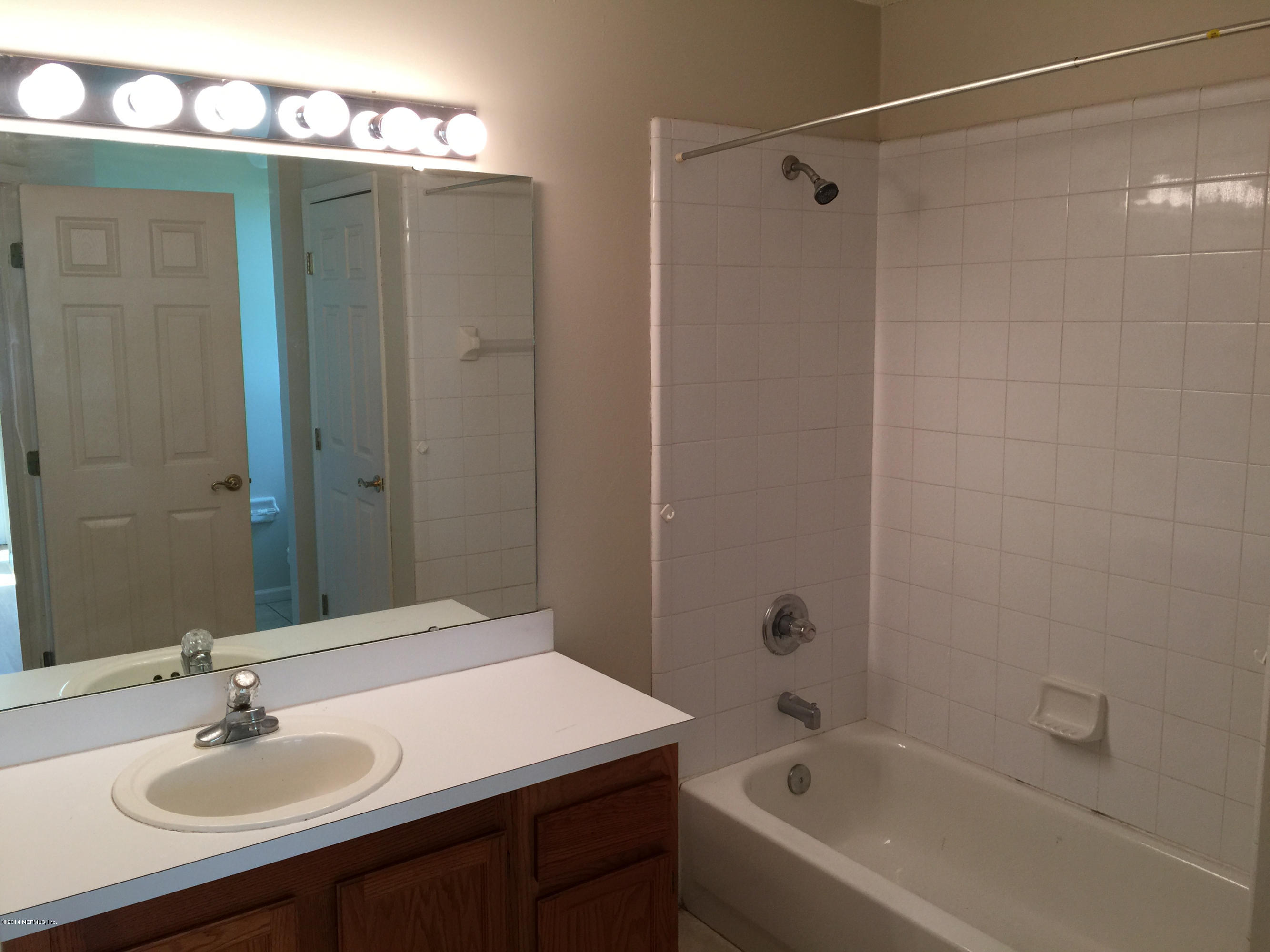 6408 Checkmate Lane Jacksonville, FL 32244 - Photo 11 of 18 a bathroom with a bathtub shower sink and mirror