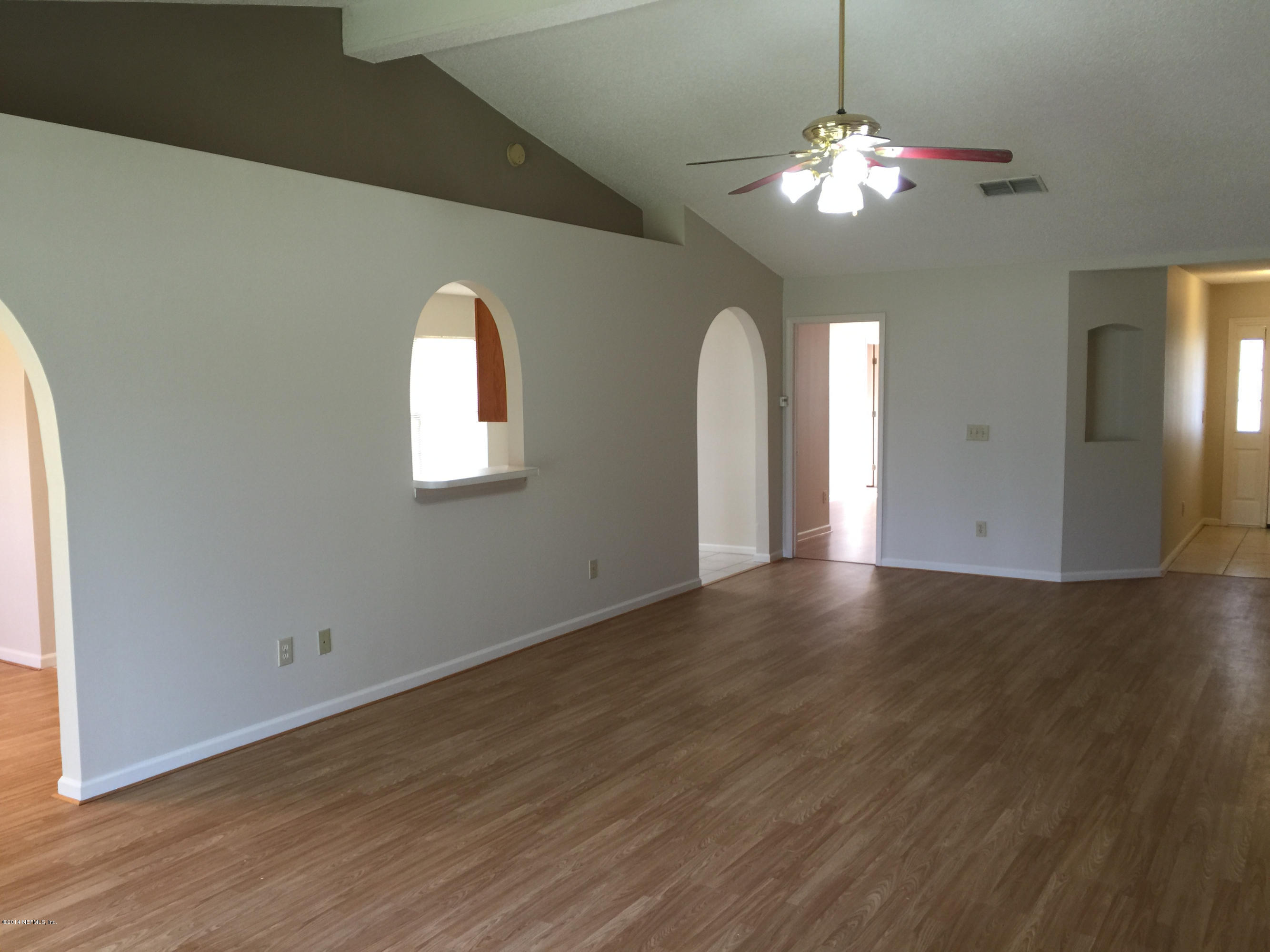6408 Checkmate Lane Jacksonville, FL 32244 - Photo 15 of 18 an empty room with wooden floor chandelier and window