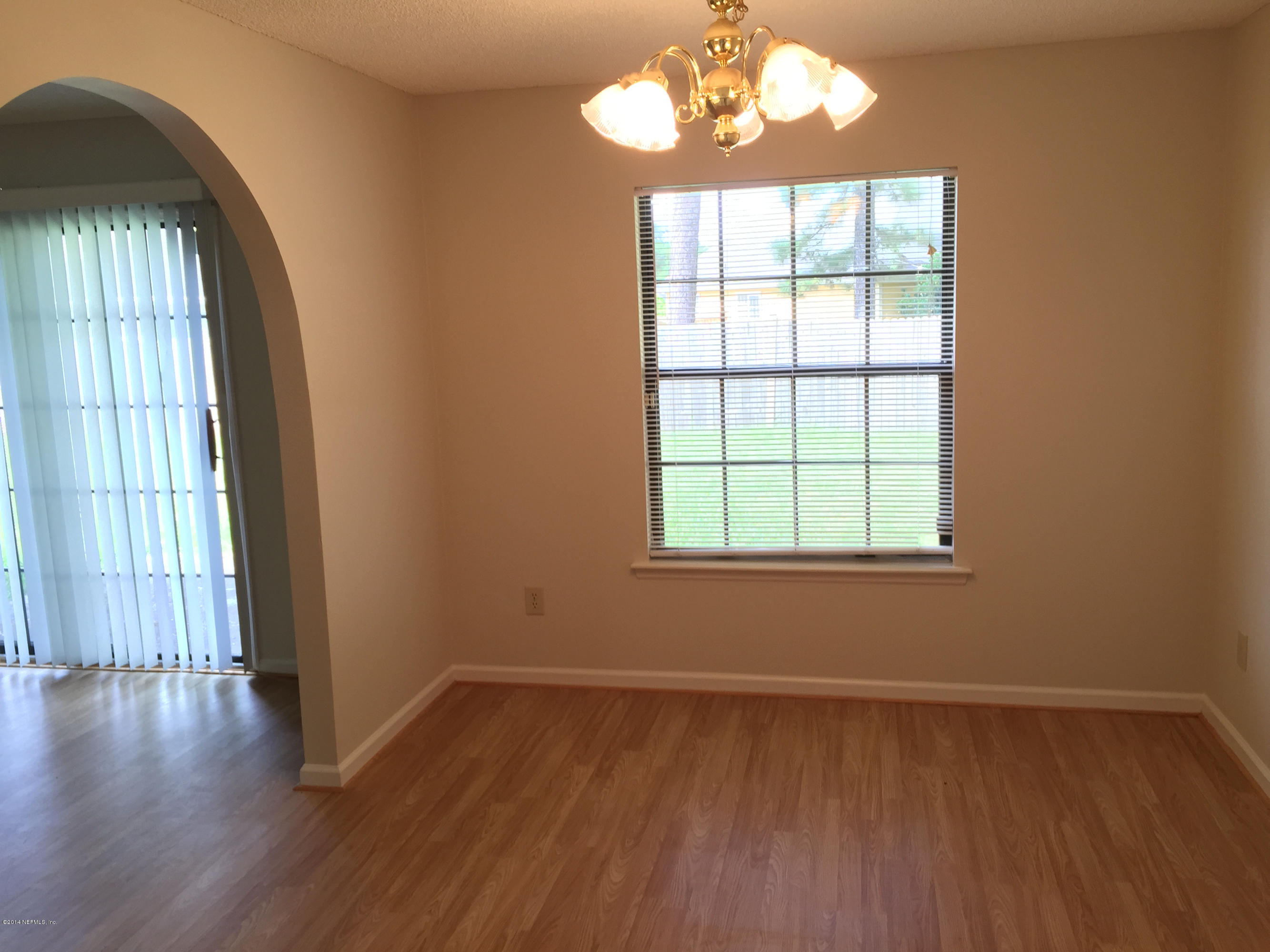 6408 Checkmate Lane Jacksonville, FL 32244 - Photo 8 of 18 a view of an empty room with wooden floor and a window