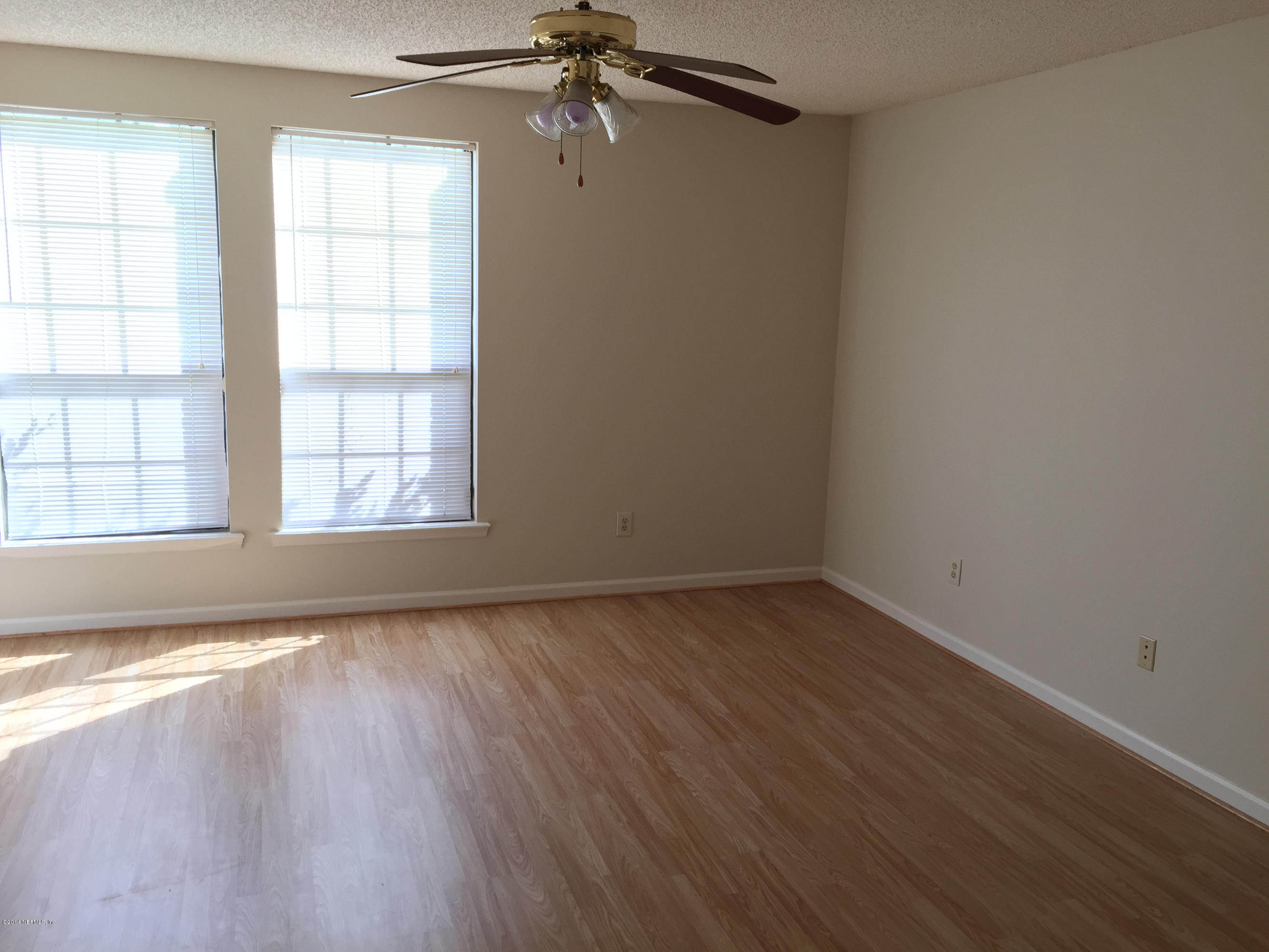 6408 Checkmate Lane Jacksonville, FL 32244 - Photo 9 of 18 an empty room with wooden floor chandelier fan and windows