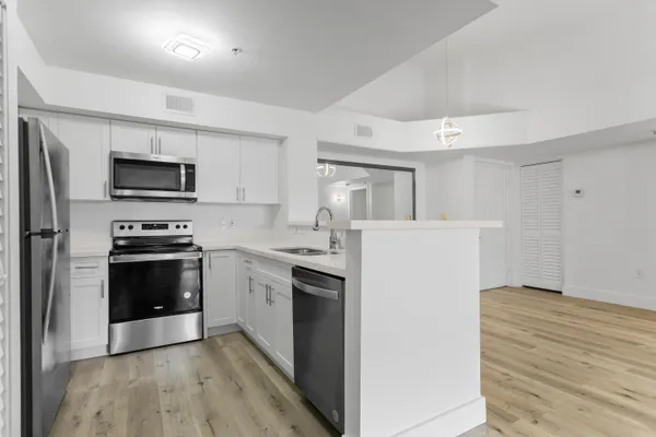 a kitchen with granite countertop a refrigerator stove and sink