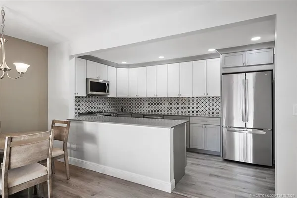 a kitchen with stainless steel appliances a refrigerator and a stove top oven
