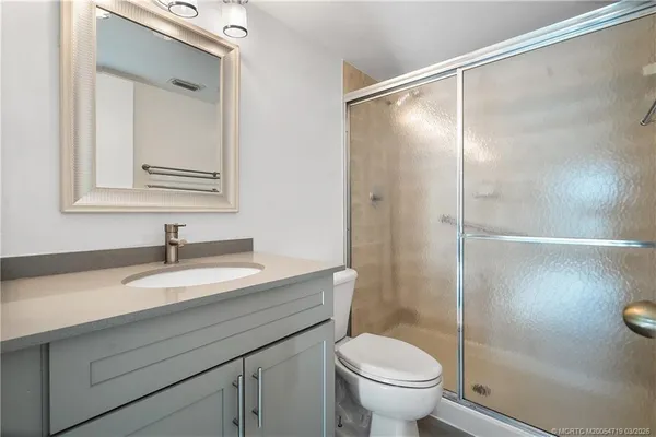 a bathroom with a granite countertop sink toilet and shower