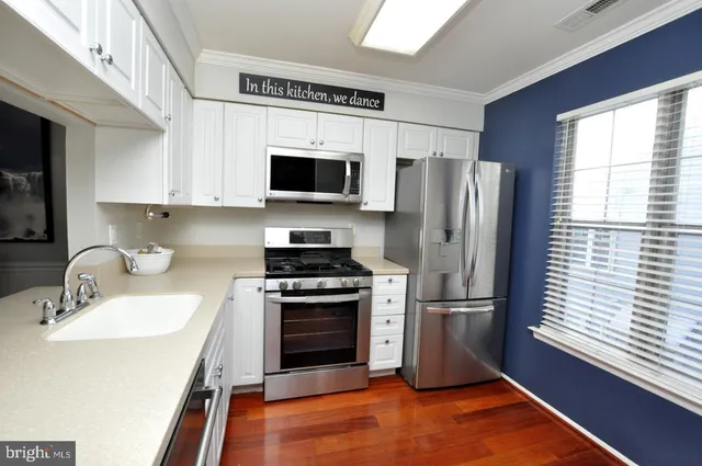 a kitchen with stainless steel appliances a refrigerator stove and microwave