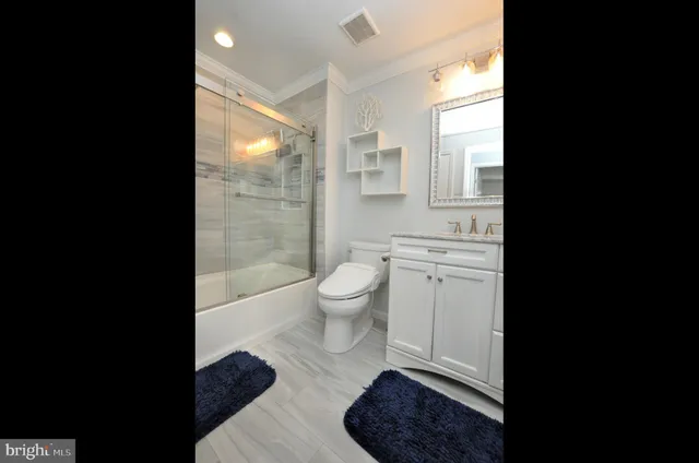 a bathroom with a toilet a sink a mirror a vanity and a window