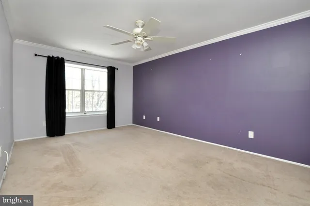 a view of an empty room with a ceiling fan
