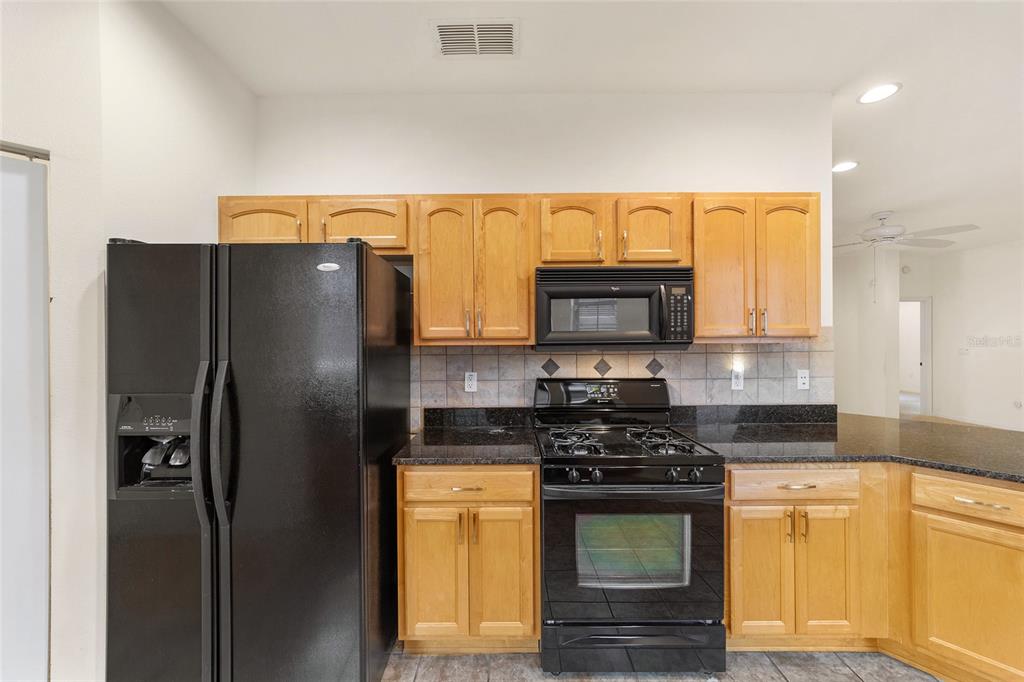 8434 Southwest 82nd Loop Ocala, FL 34481 - Photo 19 of 41 a kitchen with stainless steel appliances granite countertop a refrigerator a stove and a sink