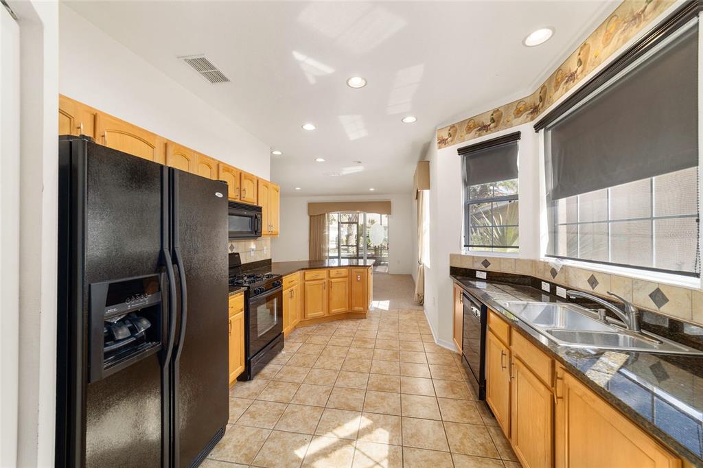 8434 Southwest 82nd Loop Ocala, FL 34481 - Photo 21 of 41 a kitchen with stainless steel appliances granite countertop a sink stove and refrigerator