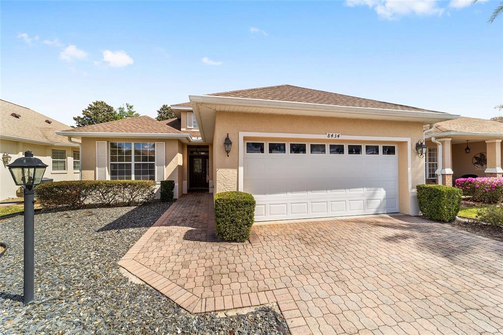 8434 Southwest 82nd Loop Ocala, FL 34481 - Photo 6 of 41 a front view of a house with a yard and potted plants