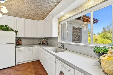 a kitchen with granite countertop white cabinets and white appliances