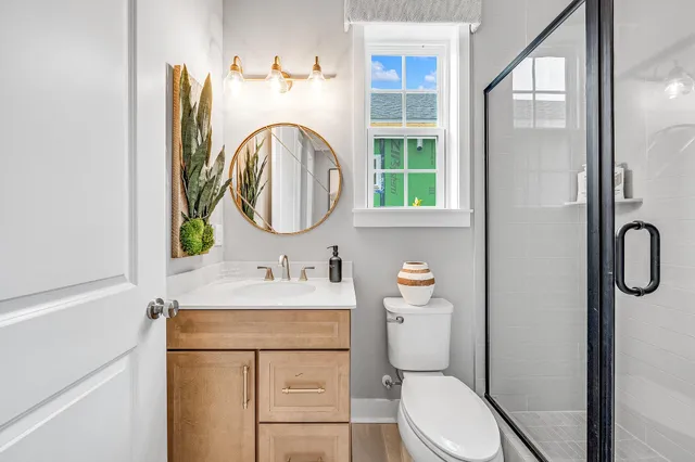 a bathroom with a toilet sink vanity and mirror