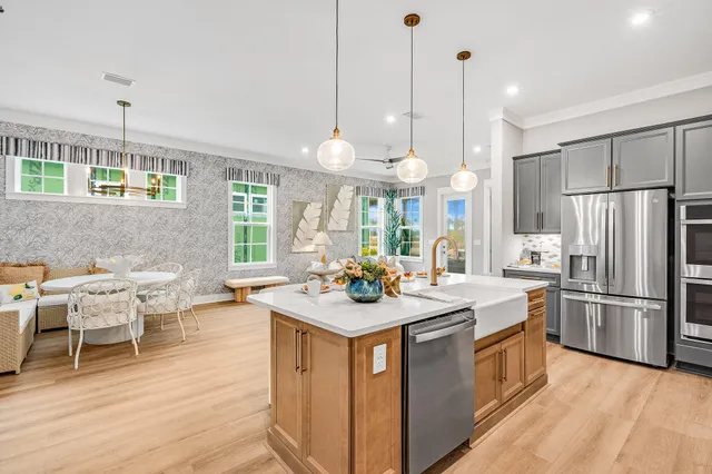 a kitchen with a sink stove and wooden floor