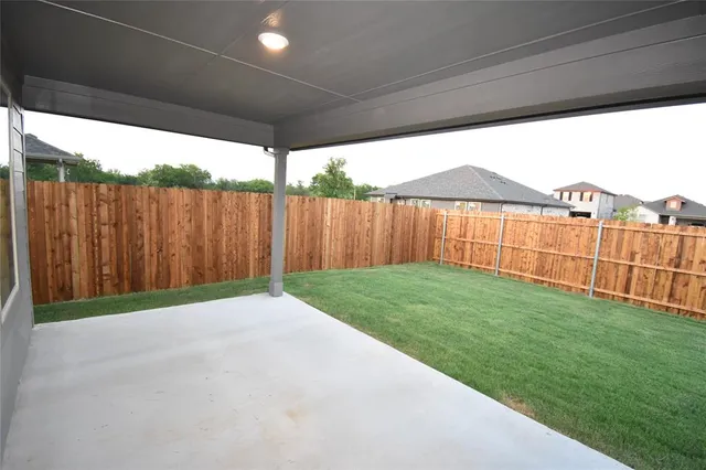 a view of a backyard with wooden fence