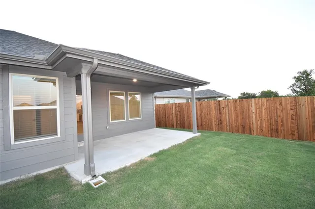 a view of a backyard with wooden fence