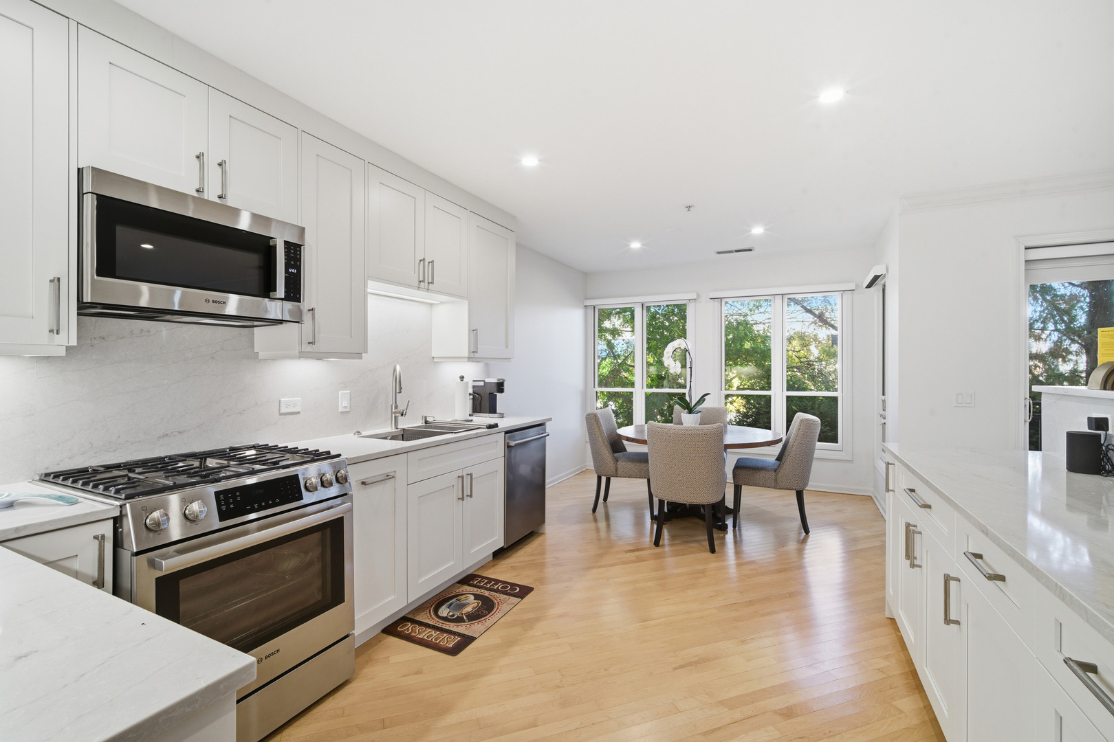 1688 Green Bay Road, Unit 204 Highland Park, IL 60035 - Photo 2 of 14 a kitchen with stainless steel appliances a stove a sink dishwasher a microwave oven with white cabinets and wooden floor