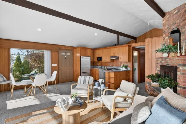 a living room with fireplace furniture and a large window