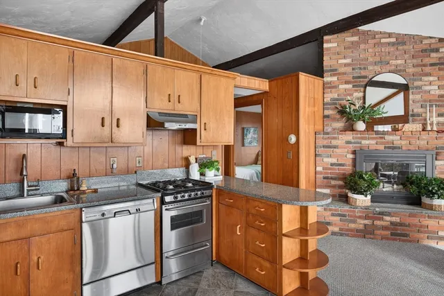a kitchen with stainless steel appliances granite countertop a stove a sink and a refrigerator