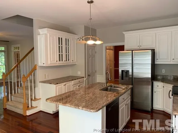 a kitchen with stainless steel appliances granite countertop a sink refrigerator and cabinets