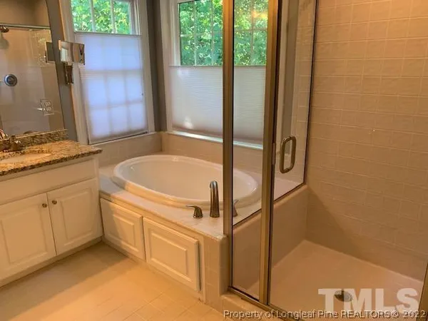 a bathroom with a tub sink and mirror