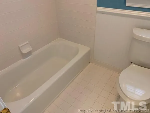 a bath tub sitting next to a white toilet and a sink