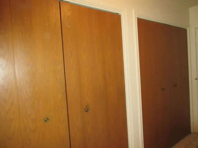 a backyard of a house with wooden fence and large trees