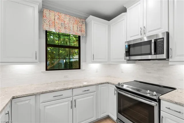 a large kitchen with stainless steel appliances lots of counter space and a sink