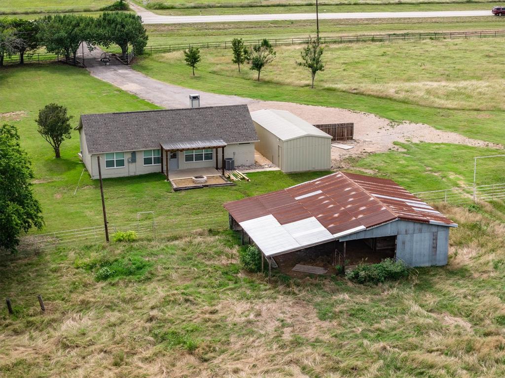 13132 Highway 78 Blue Ridge, TX 75424 - Photo 29 of 35 Single-story residence with a covered patio, gravel driveway, and a detached metal storage building
