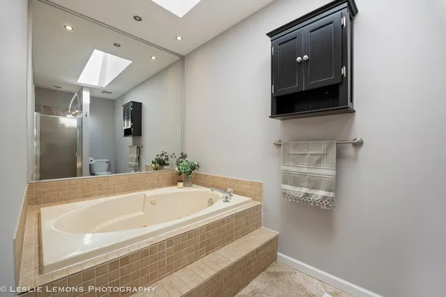 a spacious bathroom with a tub and mirror