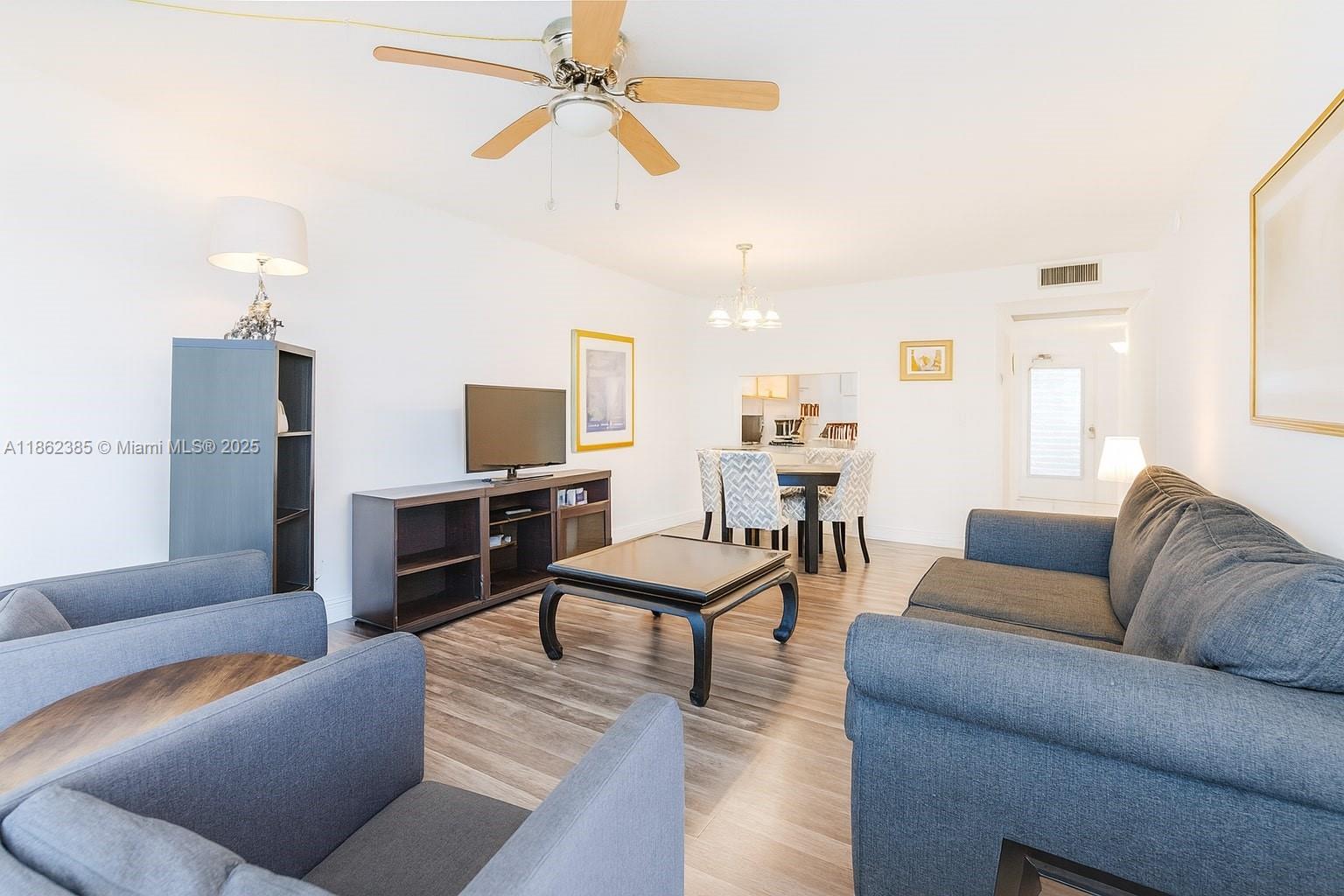 9330 Lagoon Place, Unit 206 Davie, FL 33324 - Photo 1 of 17 a living room with furniture kitchen view and a flat screen tv