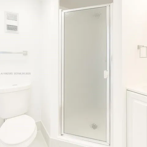 a white toilet sitting next to a shower
