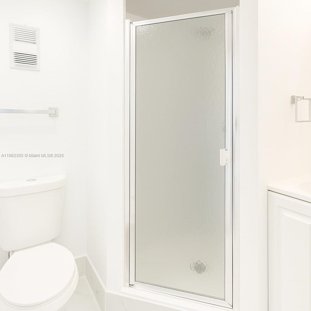 9330 Lagoon Place, Unit 206 Davie, FL 33324 - Photo 13 of 17 a white toilet sitting next to a shower