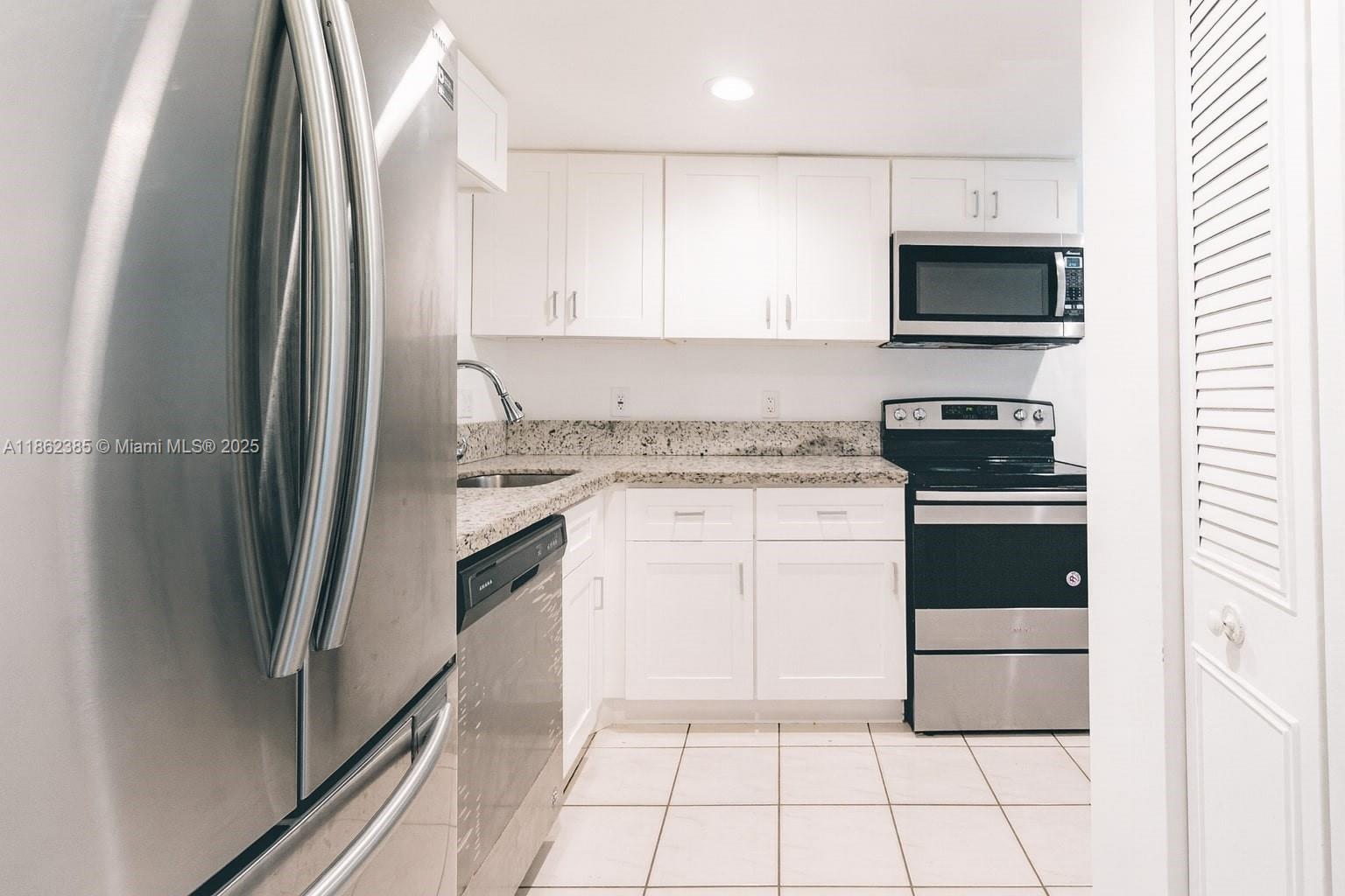 9330 Lagoon Place, Unit 206 Davie, FL 33324 - Photo 3 of 17 a kitchen with a sink and a stove top oven