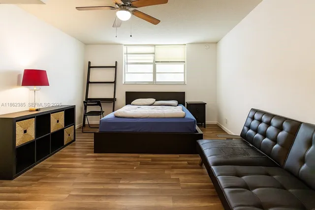 a spacious bedroom with a bed and wooden floor