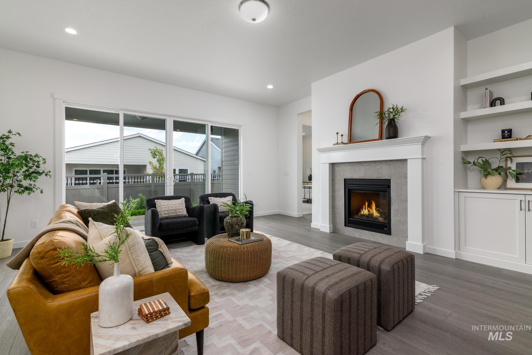 8554 West Fanning Street Star, ID 83669 - Photo 2 of 11 Living area featuring a tile fireplace, built in shelves, wood finished floors, and recessed lighting
