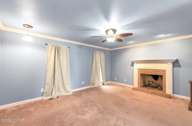 an empty room with fan and windows