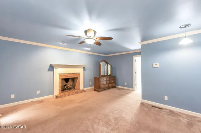 a view of a livingroom with a fireplace and chandelier fan