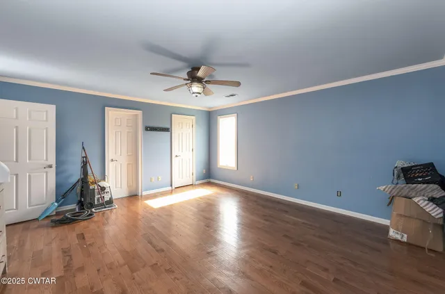 a view of a room with wooden floor and ceiling fan