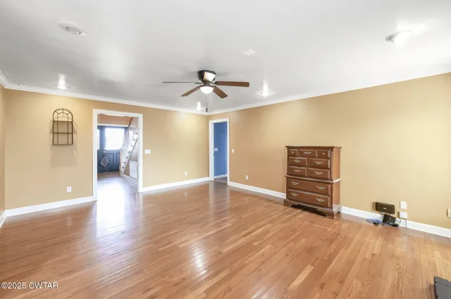a view of room with wooden floor and ceiling fan