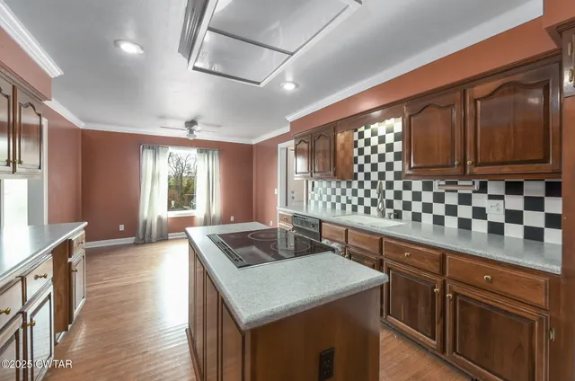 a kitchen with granite countertop a sink stove and cabinets
