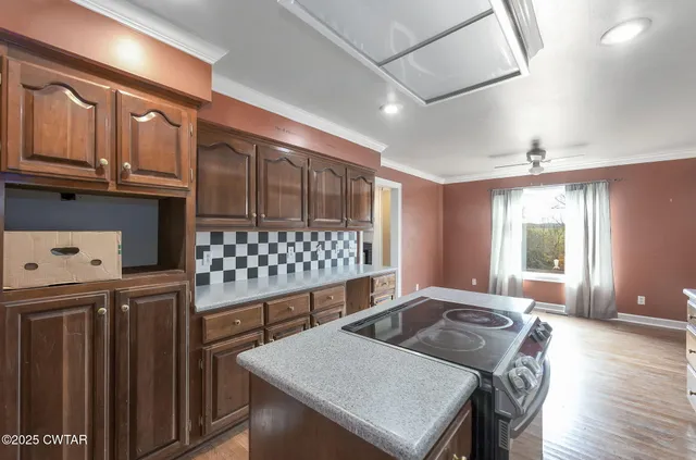 a kitchen with granite countertop a stove a sink dishwasher and cabinets with wooden floor