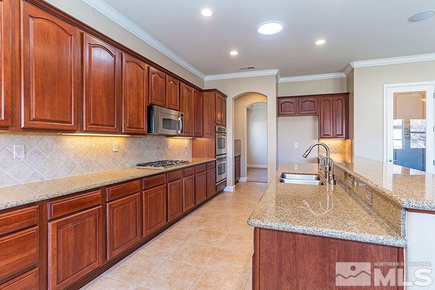 2635 Trail Rider Drive Reno, NV 89521 - Photo 12 of 25 a kitchen with stainless steel appliances granite countertop a sink a stove and a wooden cabinets
