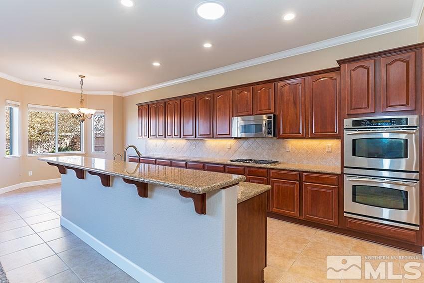 2635 Trail Rider Drive Reno, NV 89521 - Photo 14 of 25 a kitchen with stainless steel appliances granite countertop a stove a sink and a microwave